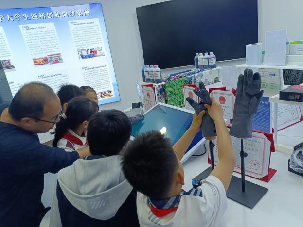 志愿者乔海清帮助小学员连接电路(2)